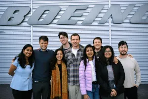 Students stand in front of a Boeing sign